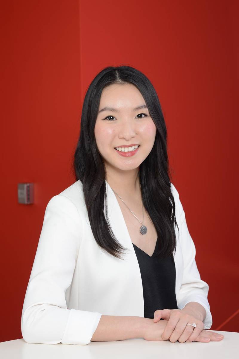 young asian girl in a white jacket on a red background