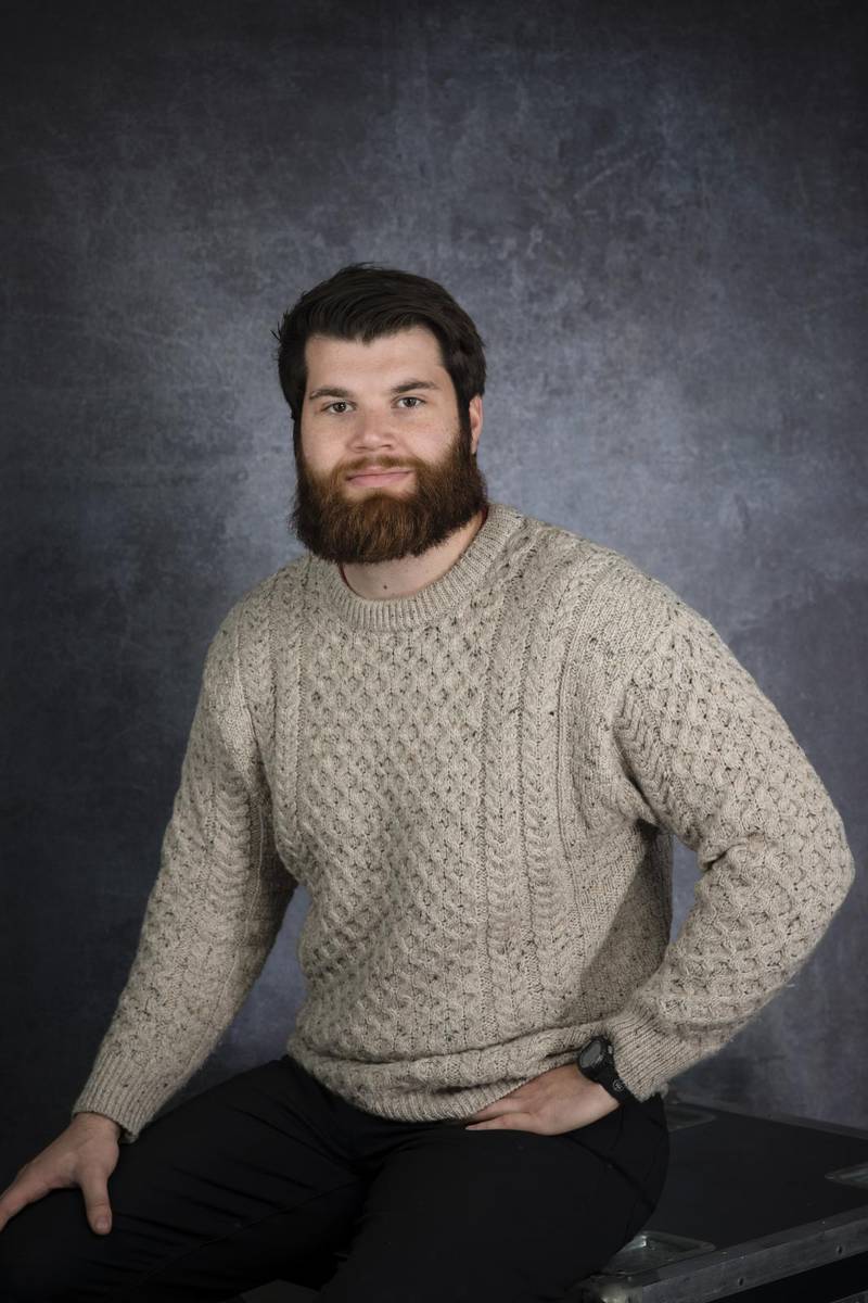 young man with a beard in a beige sweater