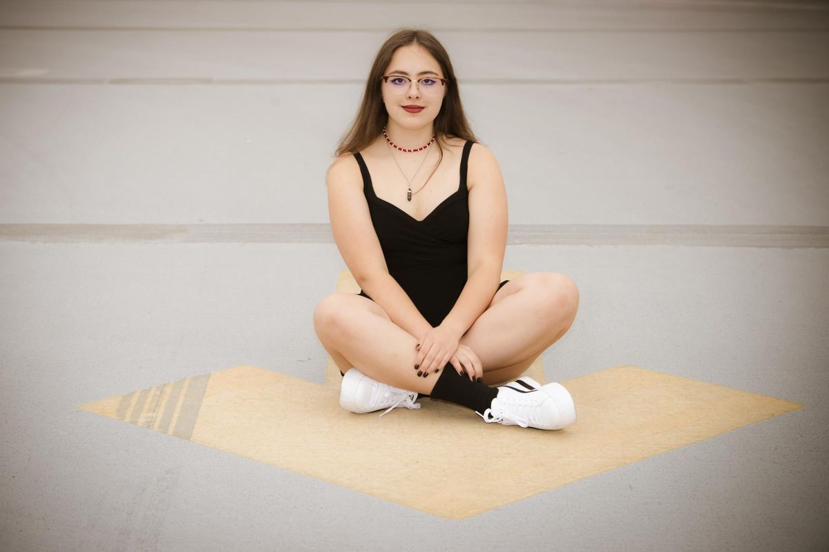 Girl sitting cross legged in a white studio