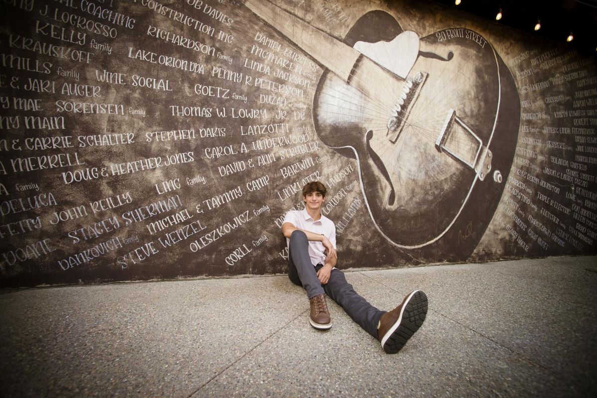Young man leaning on the wall with street painting
