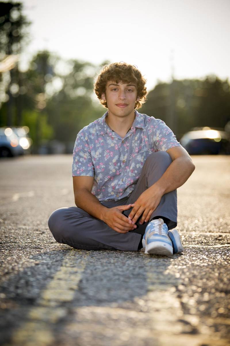 Young man sitting on the road on the median strip