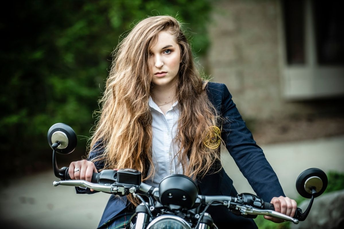 girl with long curly brown hair on motorcycle