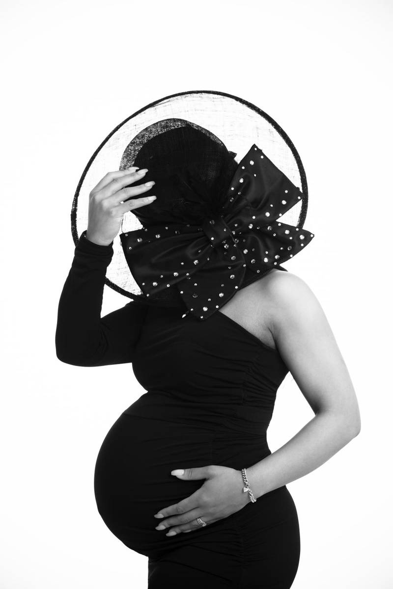 Pregnant with black hat covering her face