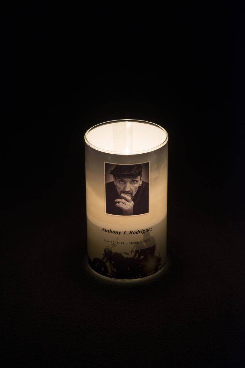 Memorial candle with a photo and dates of birth and death of the deceased