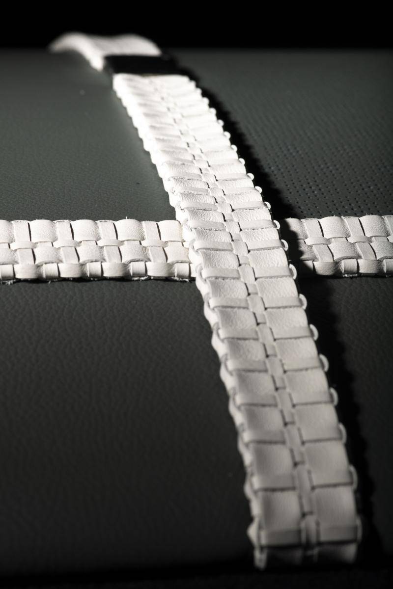 White leather braided ribbons laid out in the form of a cross
