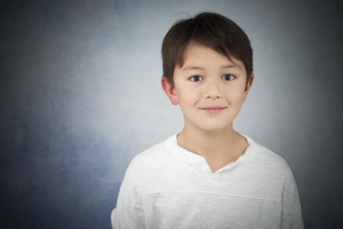 portrait of a boy with dark hair in a white shirt