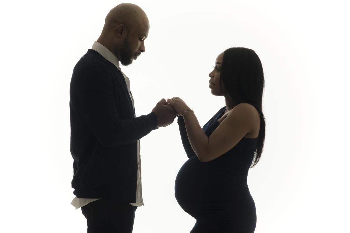 photo of a young pregnant woman holding her husband s hands
