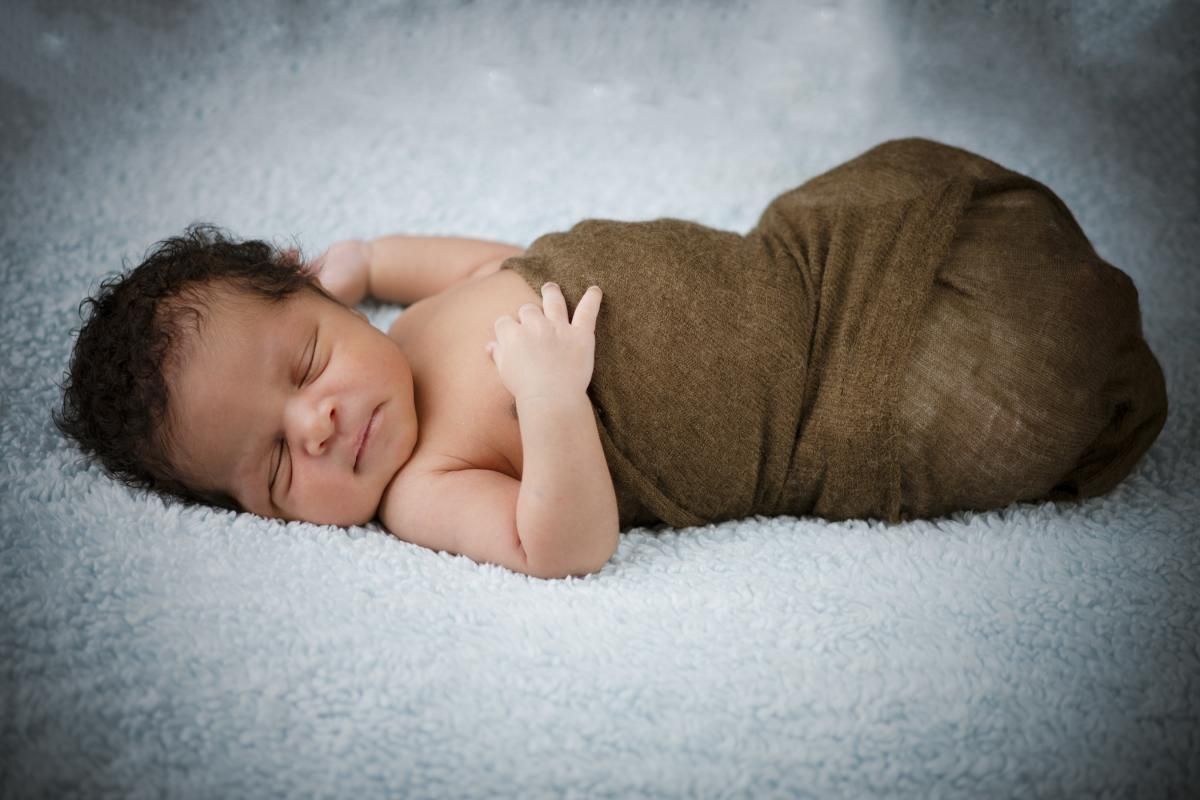 photo of a newborn lying on a soft fluffy blanket