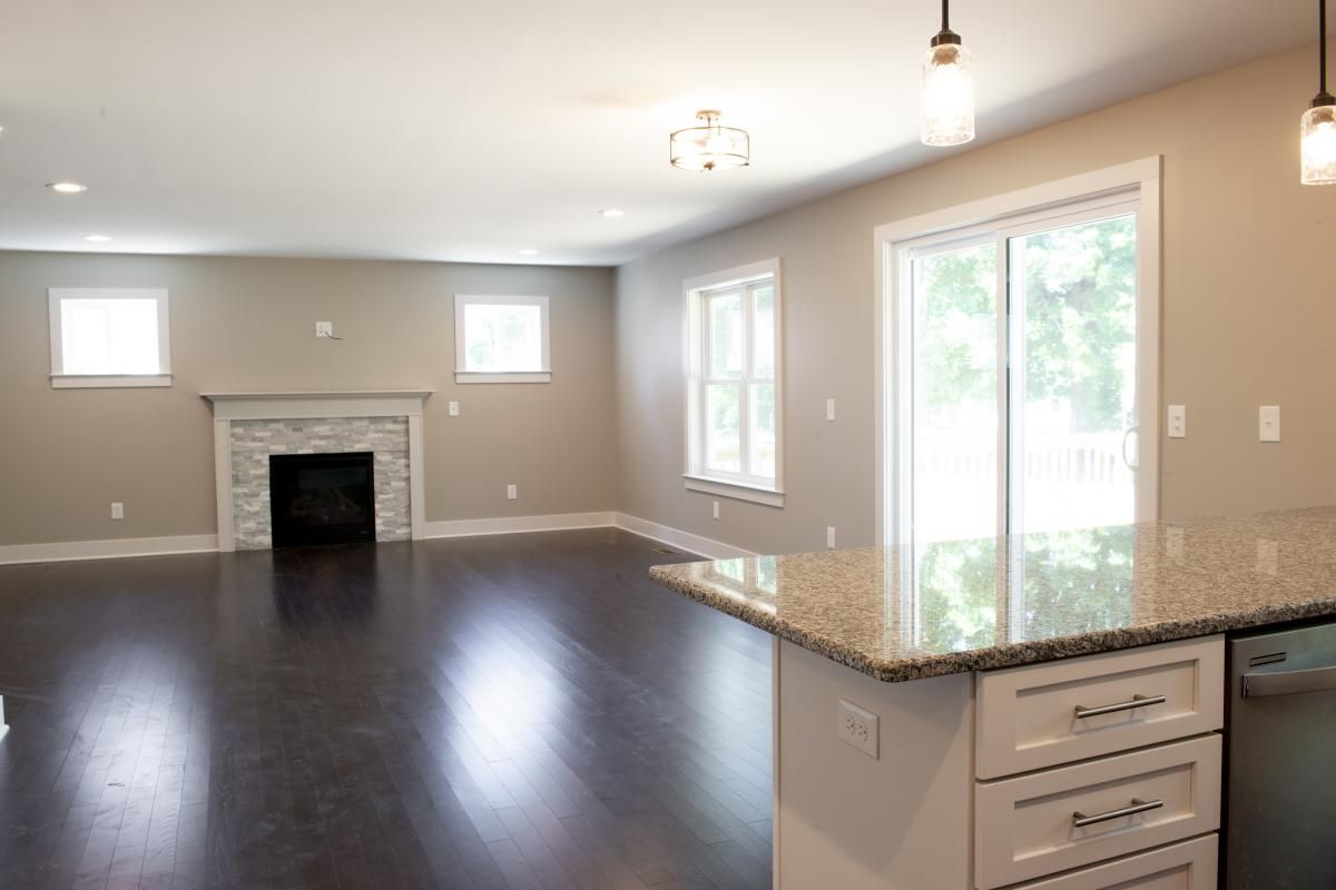 real estate photo of an empty guest room with a fireplace