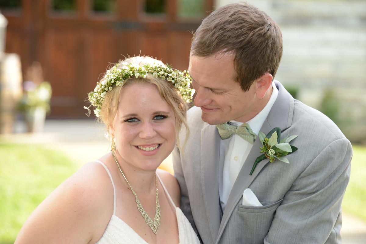 couple of newlyweds groom in a light gray suit bride with a wreath of small flowers