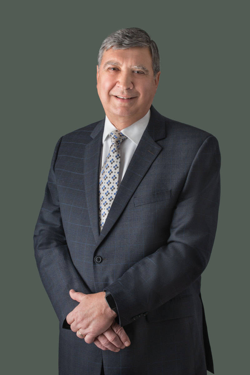a portrait photo of a man in a dark grey business suite headshot