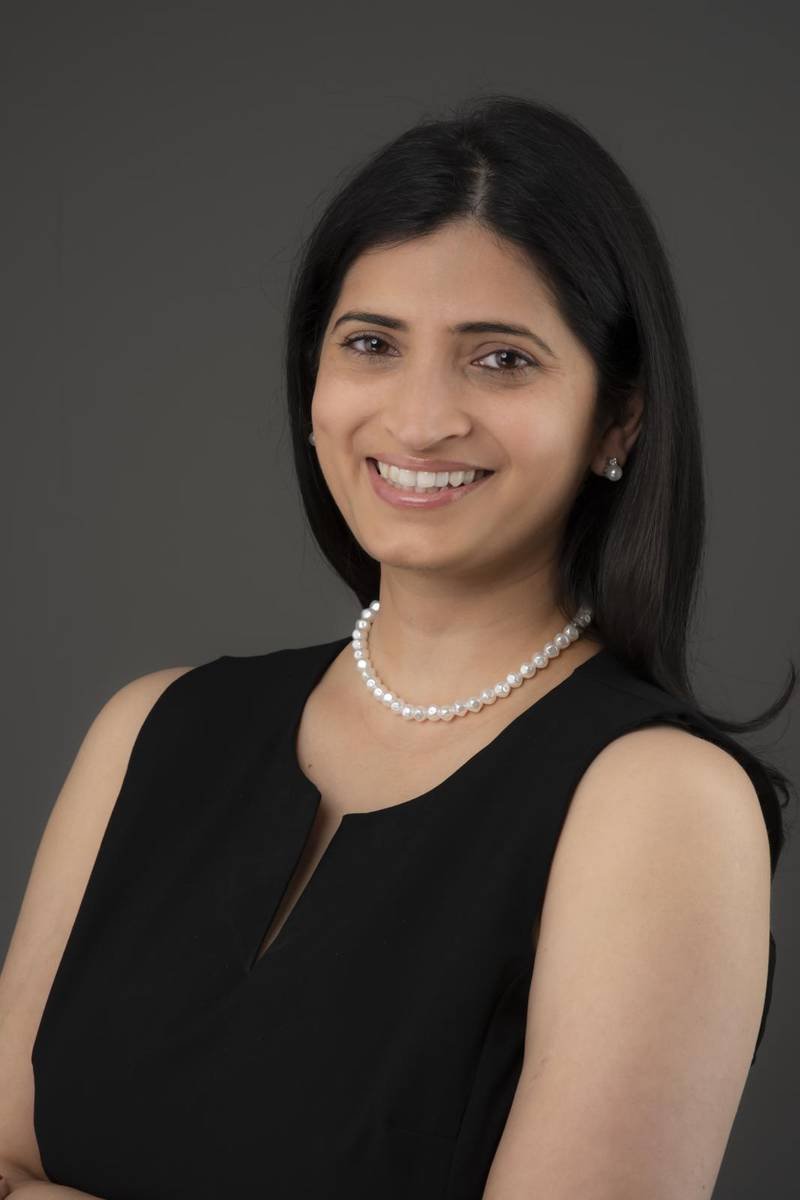 Smiling young woman with long black hair in a black dress