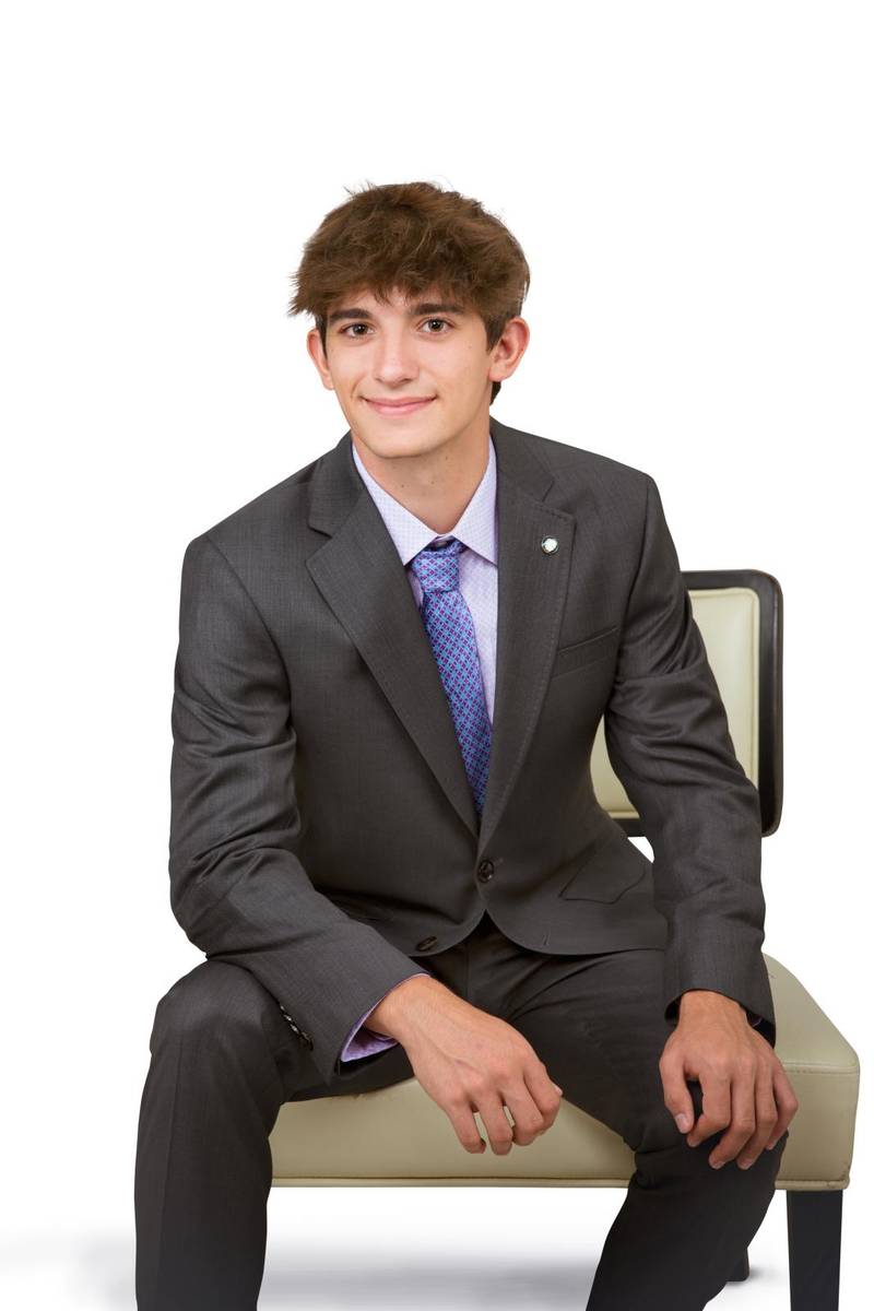 Studio portrait of school senior boy sitting on a chair